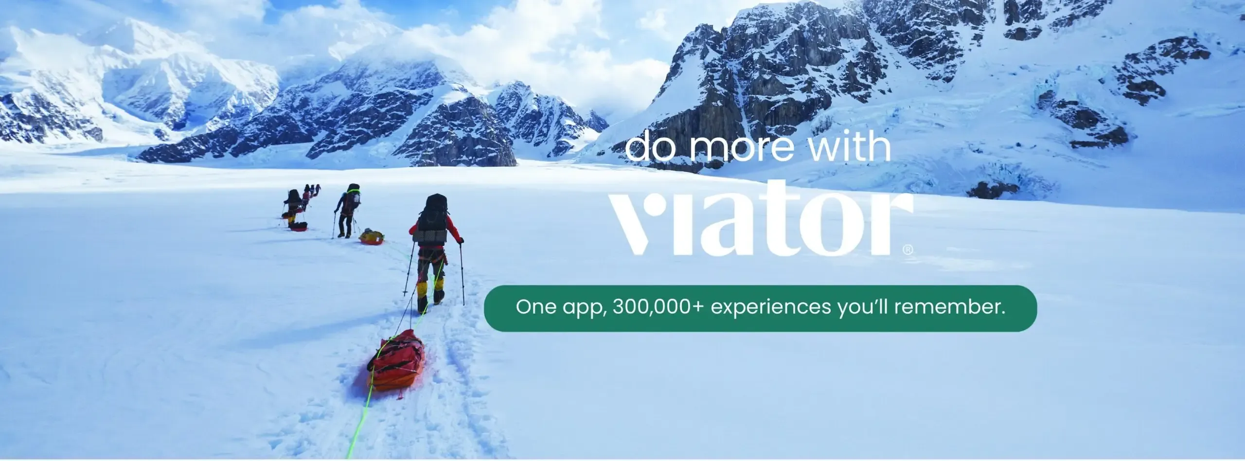 A group of adventurers treks across a vast snowy landscape with mountains.