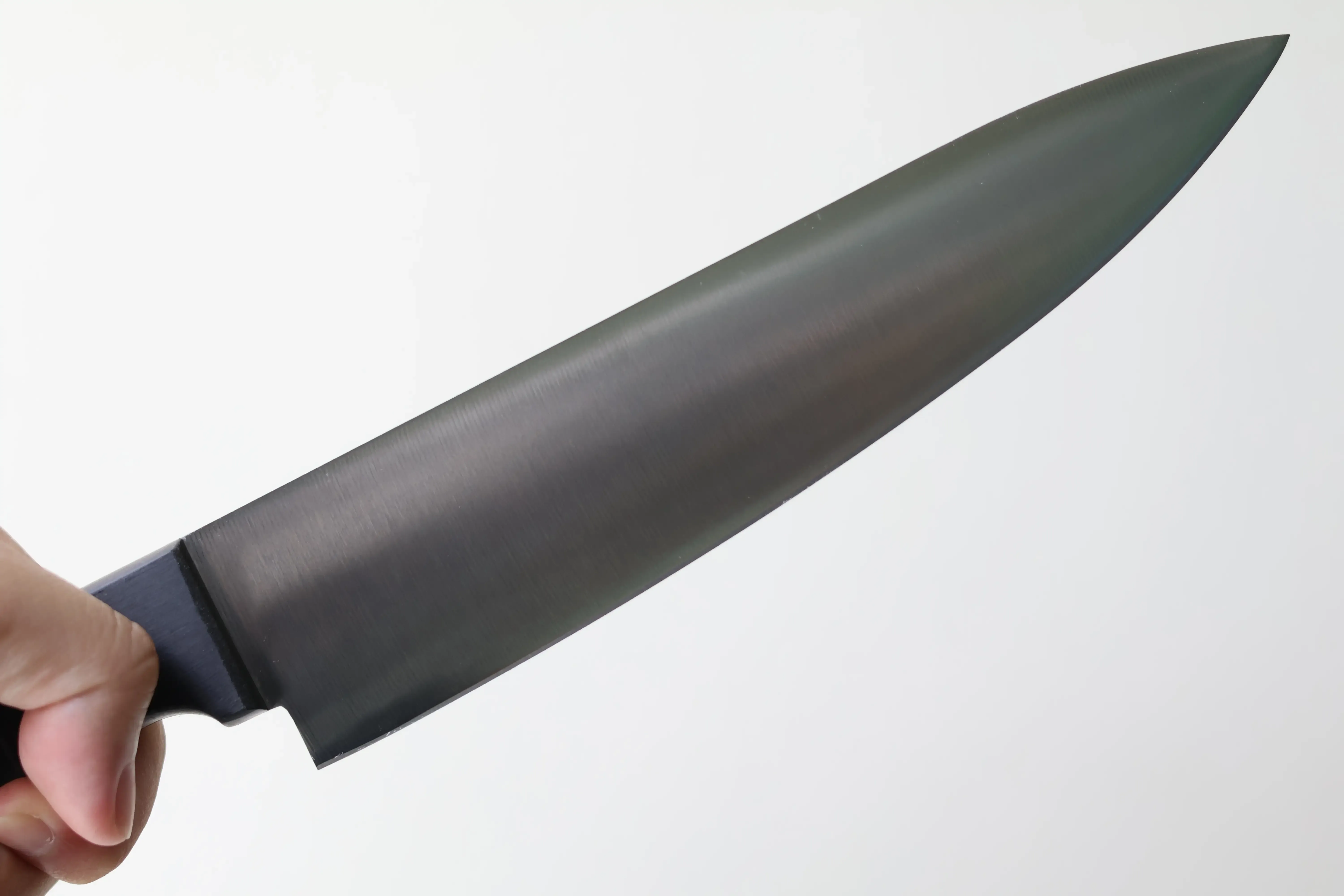 A hand holding a basic chef knife.