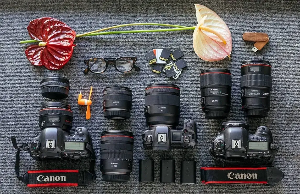 The image shows a neatly arranged flat lay of professional Canon photography gear