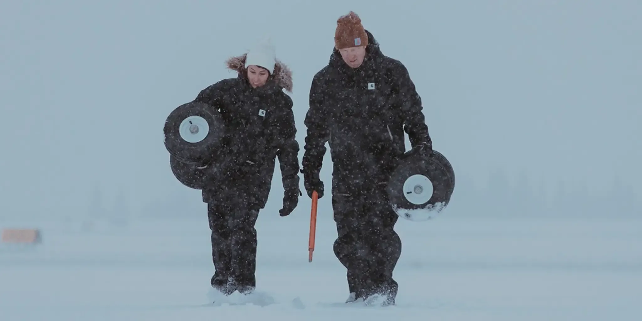 People wearing Carhartt gear walking through heavy snowfall