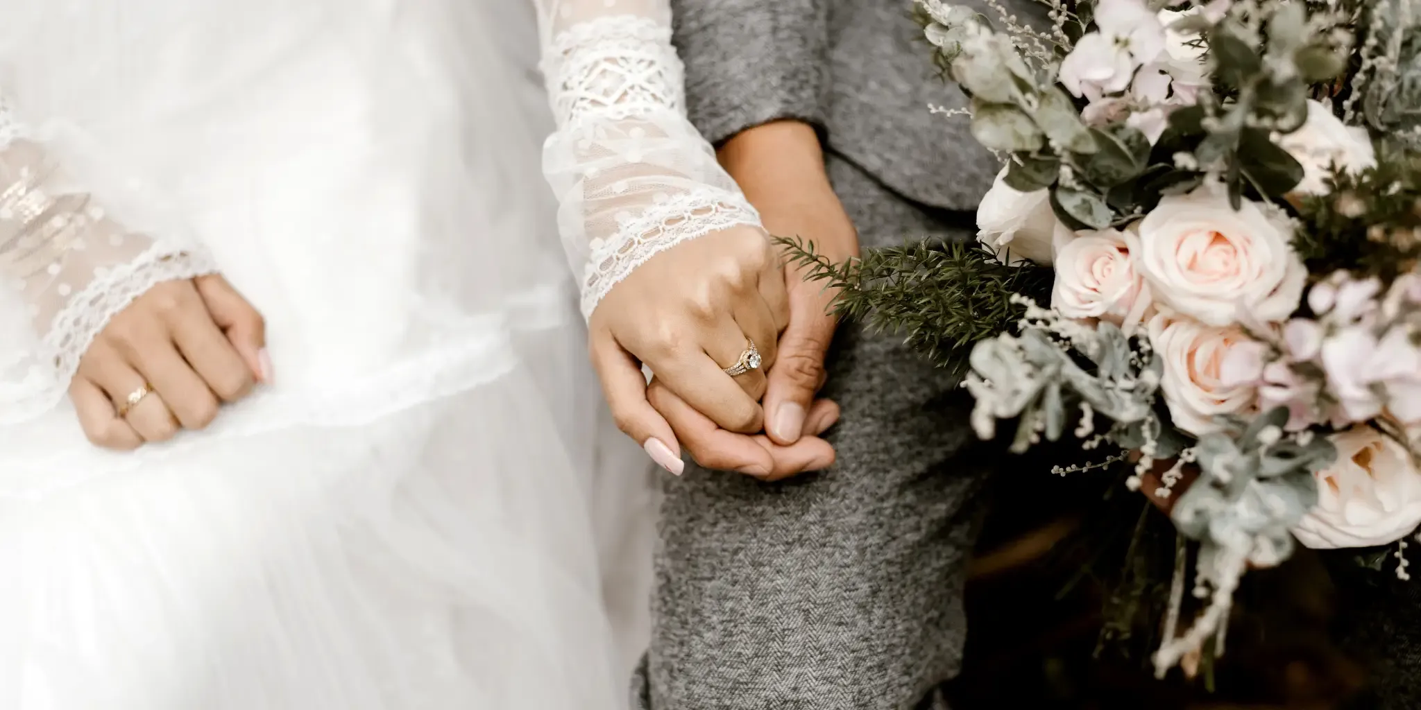 Bride and groom holding hands with flowers.
