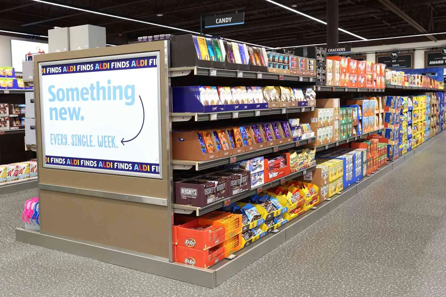 A candy aisle inside an ALDI store featuring shelves of chocolates and snacks with a sign promoting "Something new every single week". (Image: ALDI) A candy aisle inside an ALDI store featuring shelves of chocolates and snacks with a sign promoting "Something new every single week".
