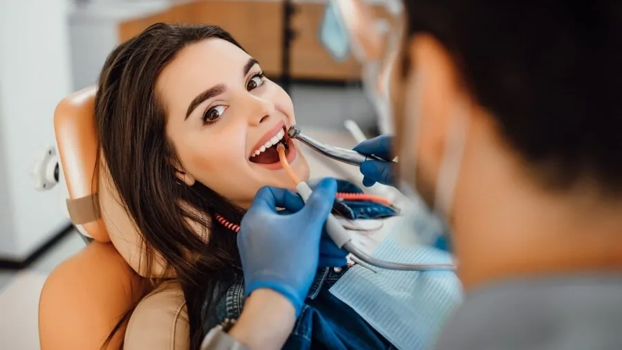 Dentist examining patient's teeth during dental checkup in modern clinic