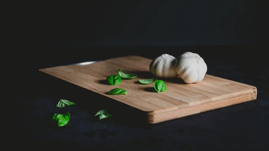 Hands chopping fresh vegetables on wooden cutting board in bright kitchen