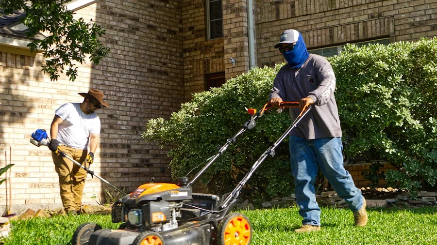 Homeowner operating lawn mower on expansive green yard during daytime maintenance