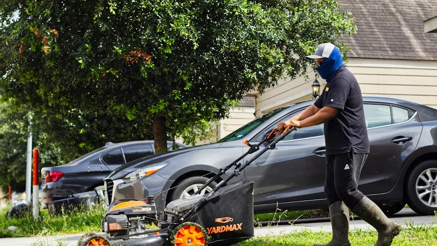 Homeowner pushing a manual lawn mower across a green residential lawn on a sunny day