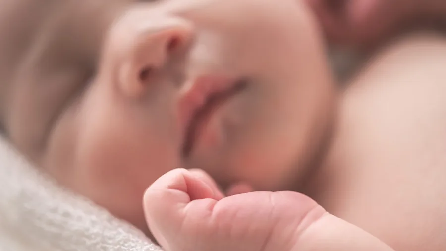 Newborn infant sleeping peacefully in reclined position with proper neck support