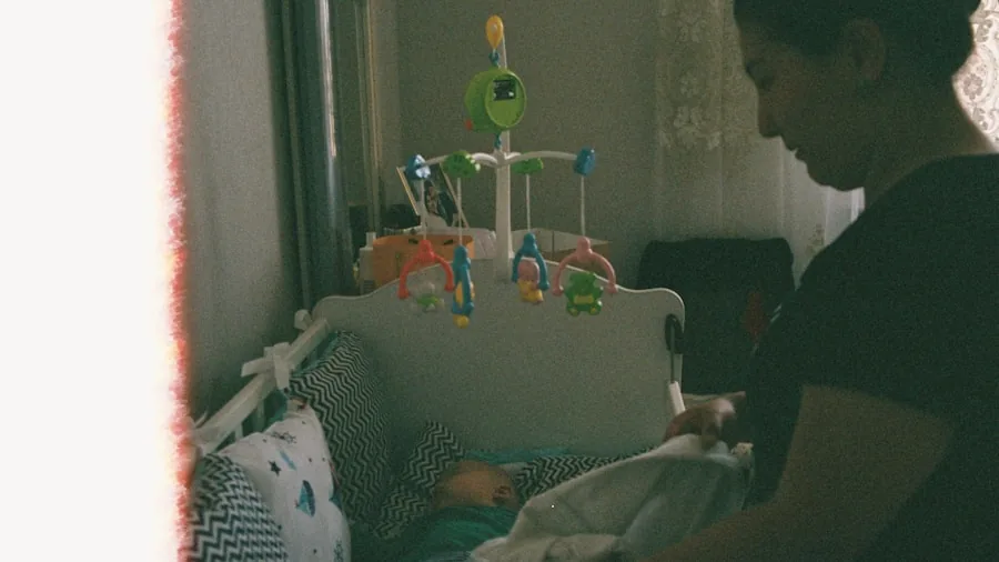 Parent checking on sleeping infant in crib at night, monitoring baby's rest and safety
