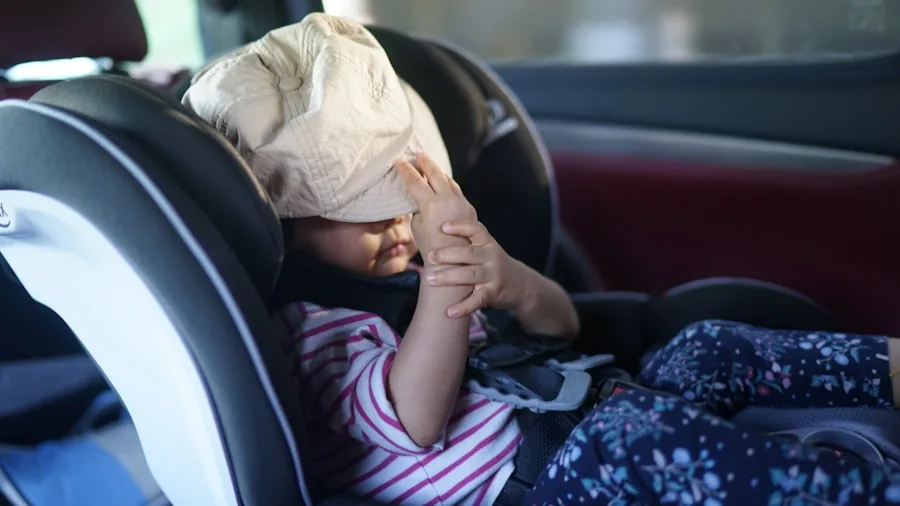 Parent gently moving sleeping baby from car seat to stroller without waking child