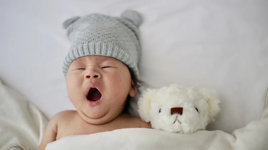 Parent watching over sleeping baby in crib at night, peaceful home monitoring scene