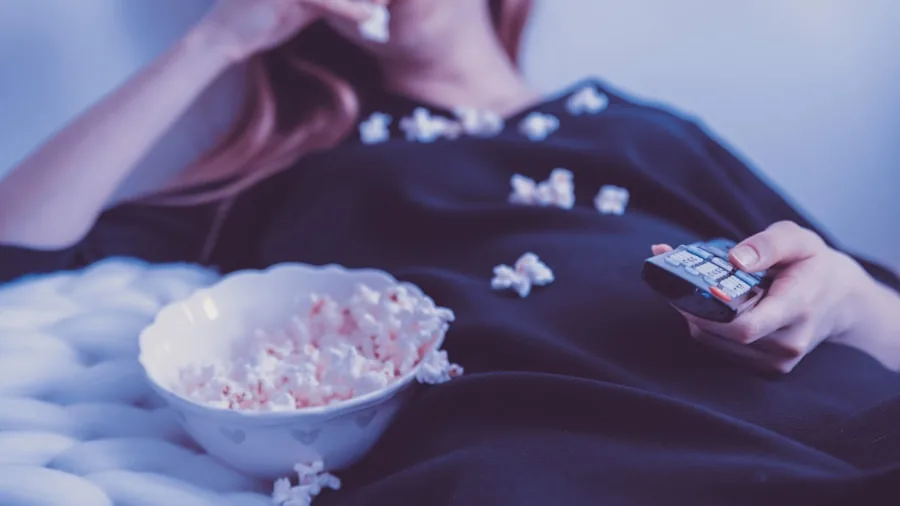 People enjoying a movie together in a cozy home setting with warm lighting