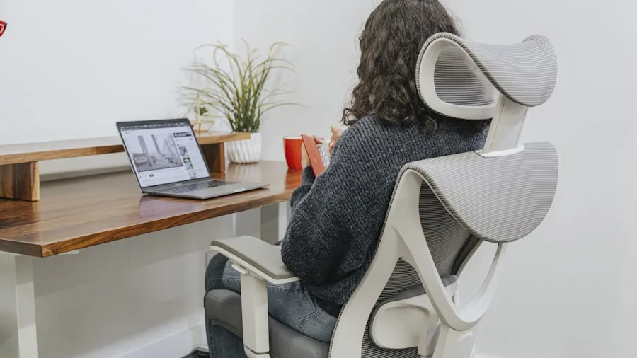 Person adjusting ergonomic chair height while sitting at desk for proper posture