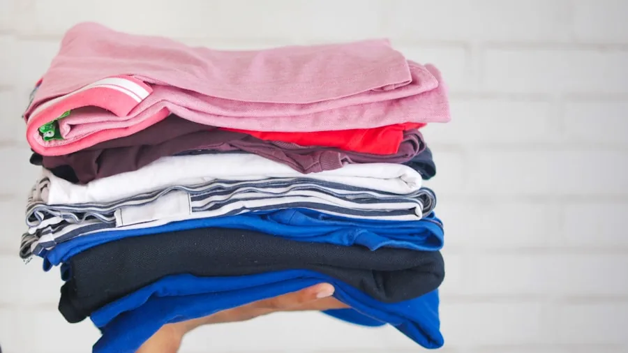 Person carefully folding soft, freshly dried clothes, demonstrating proper garment care and laundry handling