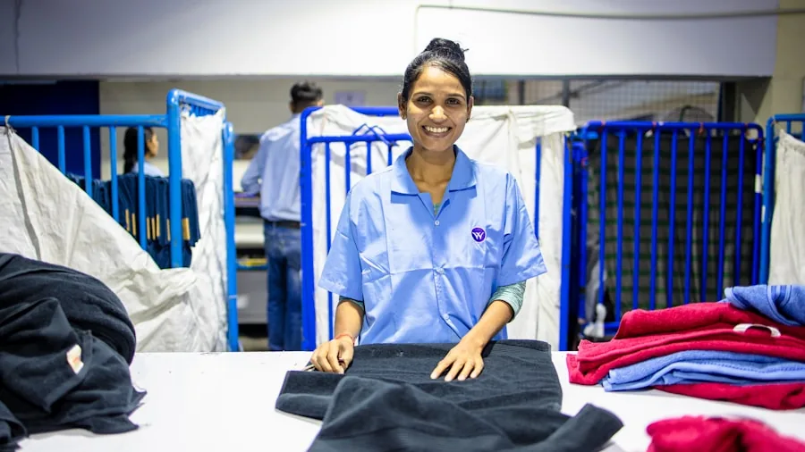 Person carefully sorting different fabric types into piles for washing, demonstrating laundry organization