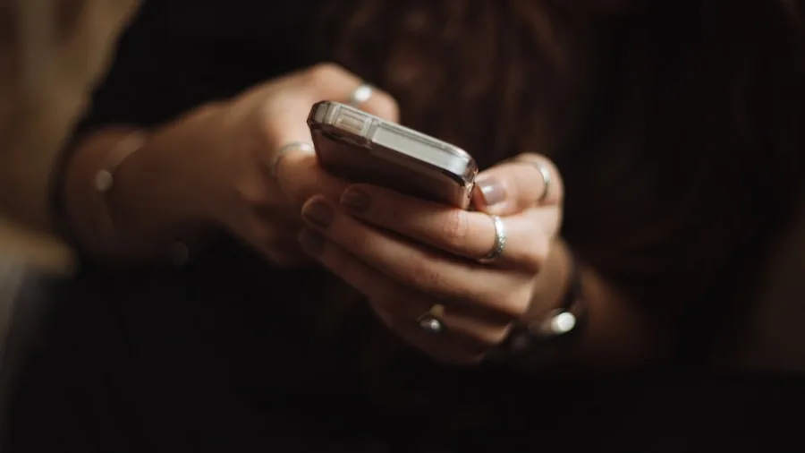 Person checking smartphone battery percentage while holding portable charger outdoors
