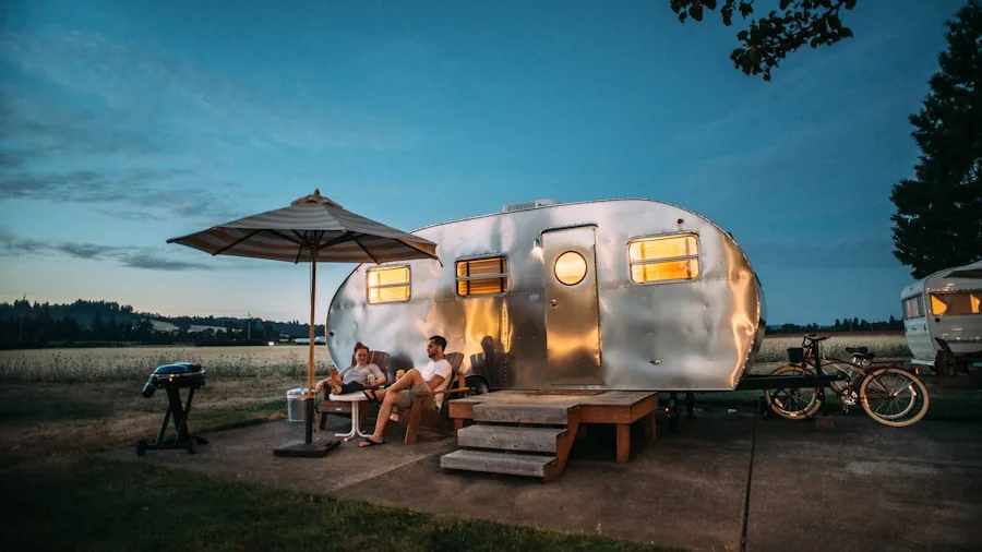 Person connecting power cable to recreational vehicle at campsite during outdoor camping trip