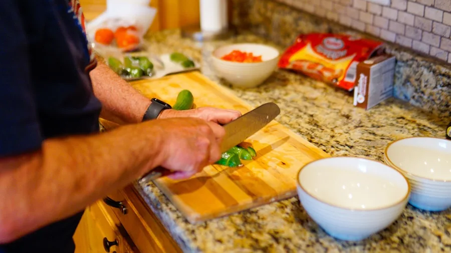 Person cutting fresh produce in bright kitchen for juicing