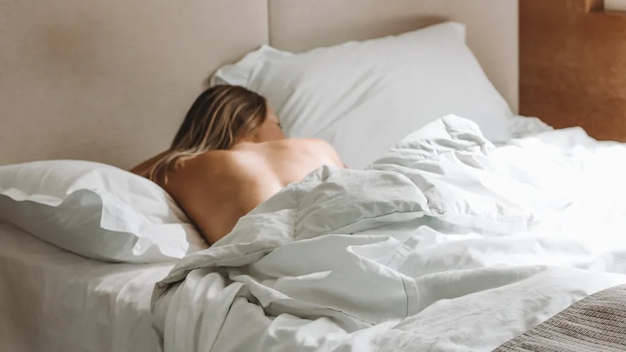 Person enjoying restful sleep in comfortable bed, representing quality mattress comfort and sleep trial confidence