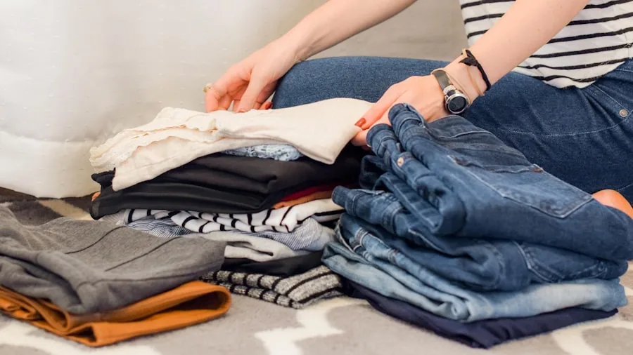 Person folding freshly dried laundry on bed in bright bedroom