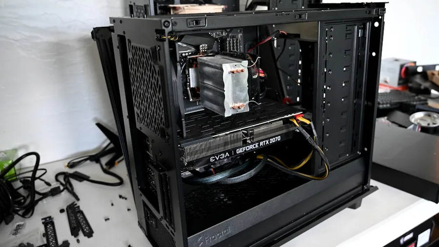 Person organizing power cables and connections behind a desktop computer workstation