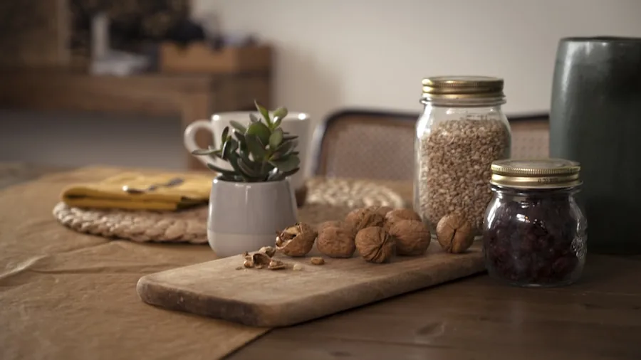 Person preparing fresh almond milk in a bright kitchen with fresh ingredients on counter
