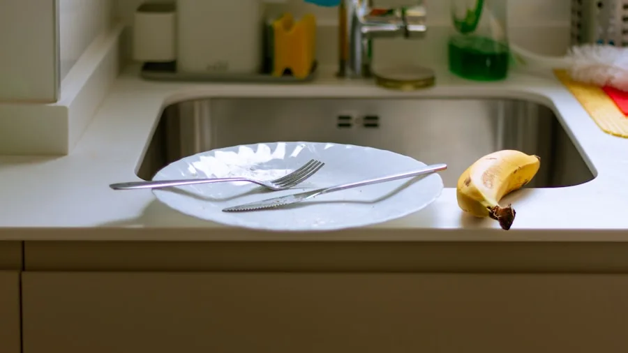 Person scraping vegetable peels and food waste into a kitchen sink during meal preparation