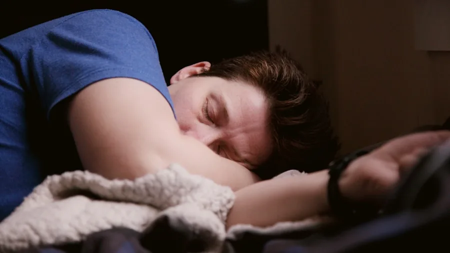 Person sleeping comfortably in bed with cool lighting, appearing restful and relaxed during nighttime