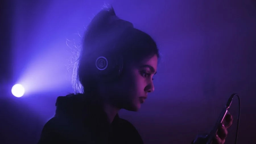 Person wearing headphones while using smartphone in everyday setting