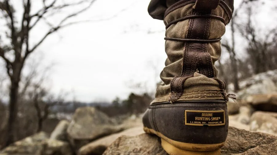 Person wearing hiking boots on a mountain trail, showing real-world use of footwear during outdoor adventure