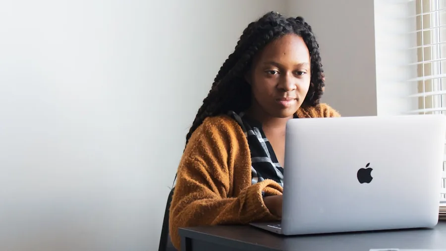 Person working on laptop at desk, focused on screen while typing