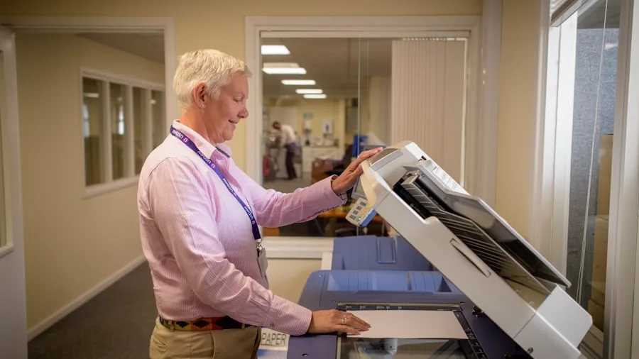 Professional in modern office managing high-volume printing tasks at desk
