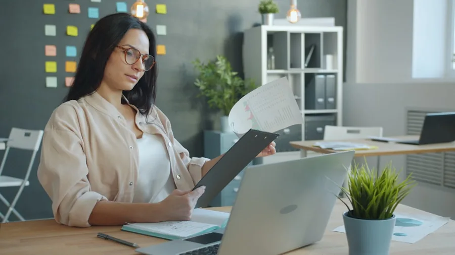 Professional organizing scattered papers at desk with filing system in background