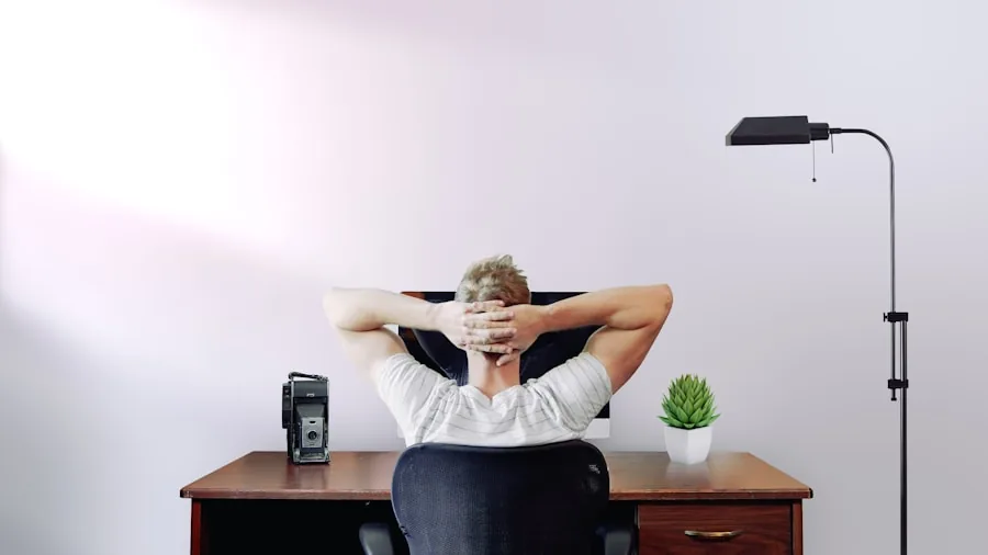 Professional with correct seated posture at workspace demonstrating proper arm and shoulder alignment