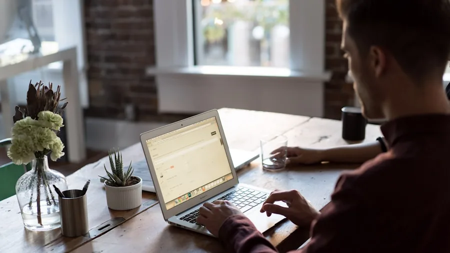 Student working on laptop at desk in casual home environment