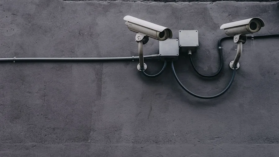 Technician installing wired security camera system on residential home exterior
