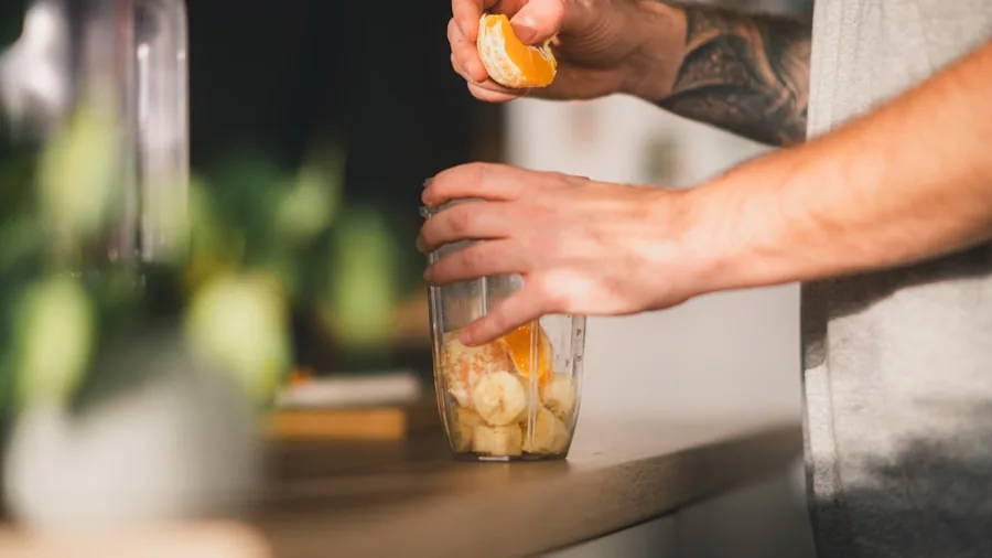 Woman preparing a fresh smoothie in a bright kitchen with blender and fresh ingredients on counter