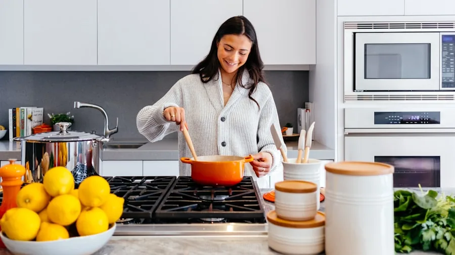 Woman preparing fresh food in modern kitchen with stainless steel cookware on stovetop